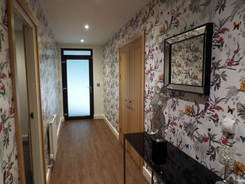 Hallway with floral wallpaper, oak doors and wood-effect flooring